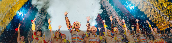Grupo de quadrilha junina se apresenta em palco iluminado